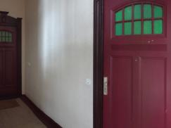 Rote Wohnungstür mit Sichtfenster in Berliner Altbau